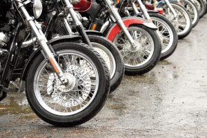 Ilustrasi sepeda-sepeda motor yang terparkir di lahan basah sehabis hujan