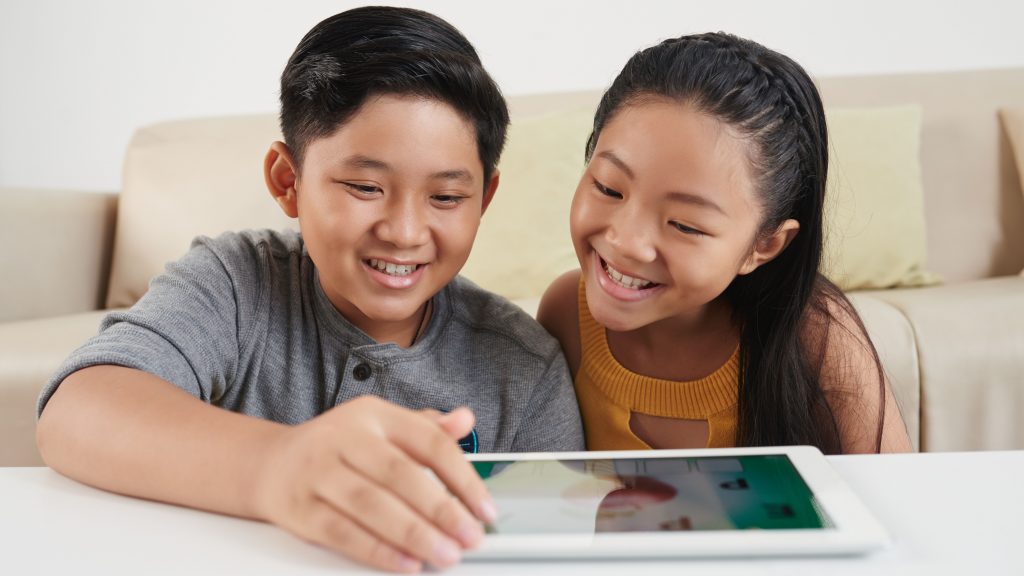 Ilustrasi dua orang remaja sedang semangat membaca di dalam tablet