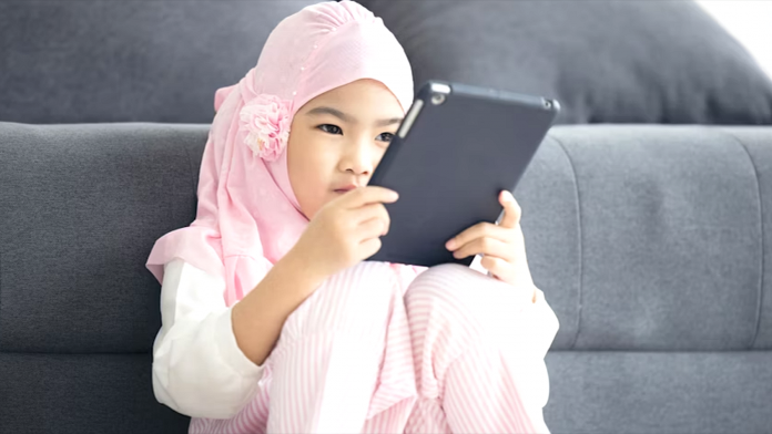 Ilustrasi anak perempuan sedang fokus belajar pada gawai tabletnya (Source: Unsplash.com)