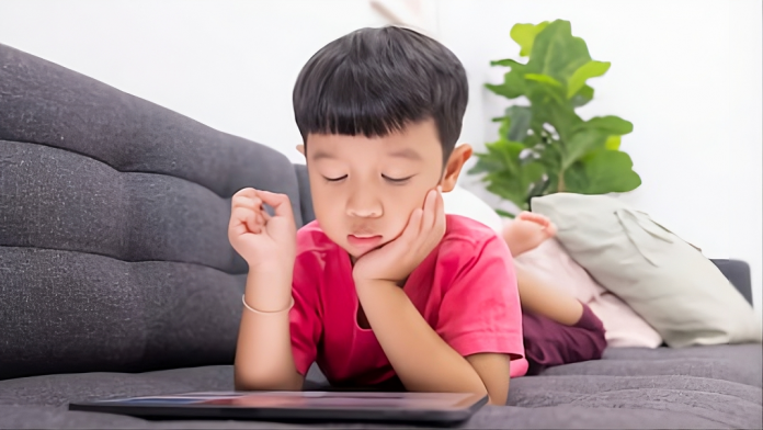 Anak laki laki sedang fokus melihat layar tablet (Source: freepik.com)