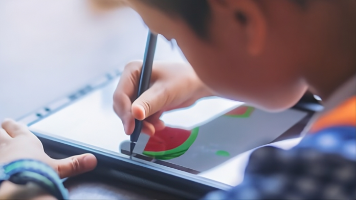 Anak laki laki sedang menggambar pada gawai (Source: Freepik.com)